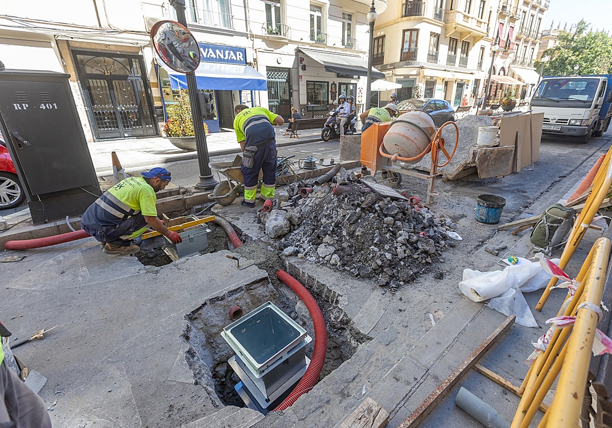 Dos operarios trabajan en la sustitución del sistema en la entrada a Plaza Nueva.