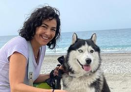 María José Rienda sostiene en la playa sus chanclas favoritas en presencia de su perro Husky.