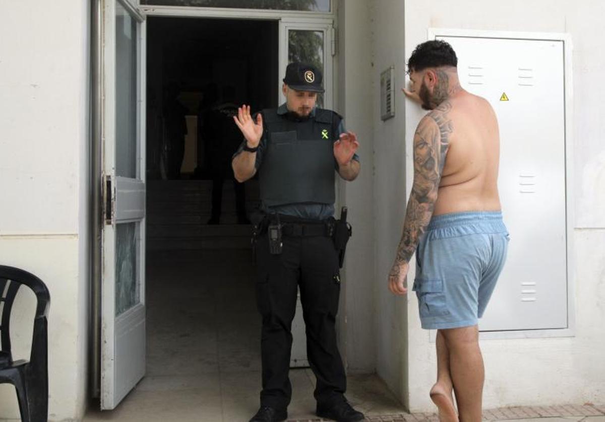 Un guardia civil en el acceso al bloque de viviendas ocupado en Atarfe.