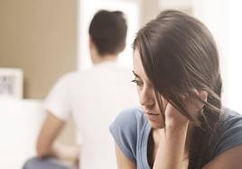 Una pareja pensando en su futuro mientras permanece sentada en la cama tras una discusión.