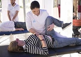 Un fisioterapeuta ayuda a un paciente.