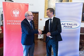 El rector de la Universidad de Granada, Pedro Mercado, y el director general de Lactalis Puleva, David Saliot, estrechan sus manos.