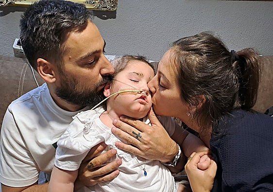 Alba, pequeña de Peligros afectada por un tumor cerebral, con sus padres Raúl y María Victoria.