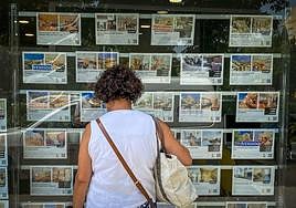 Una mujer observa las viviendas disponibles en una inmobiliaria.