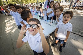Un grupo de chavales asiste al experimento presentado por un investigador.