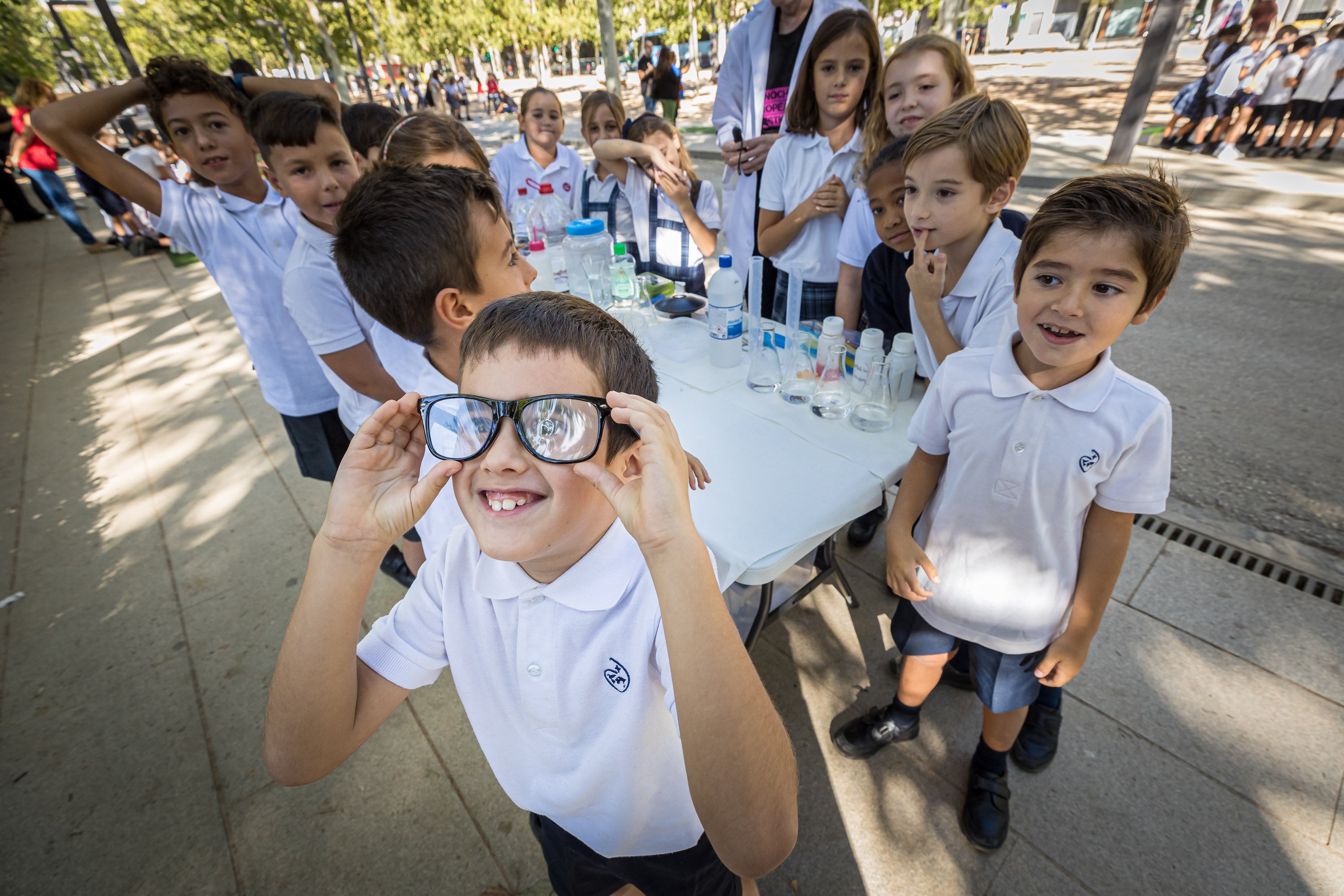 Un grupo de chavales asiste al experimento presentado por un investigador.
