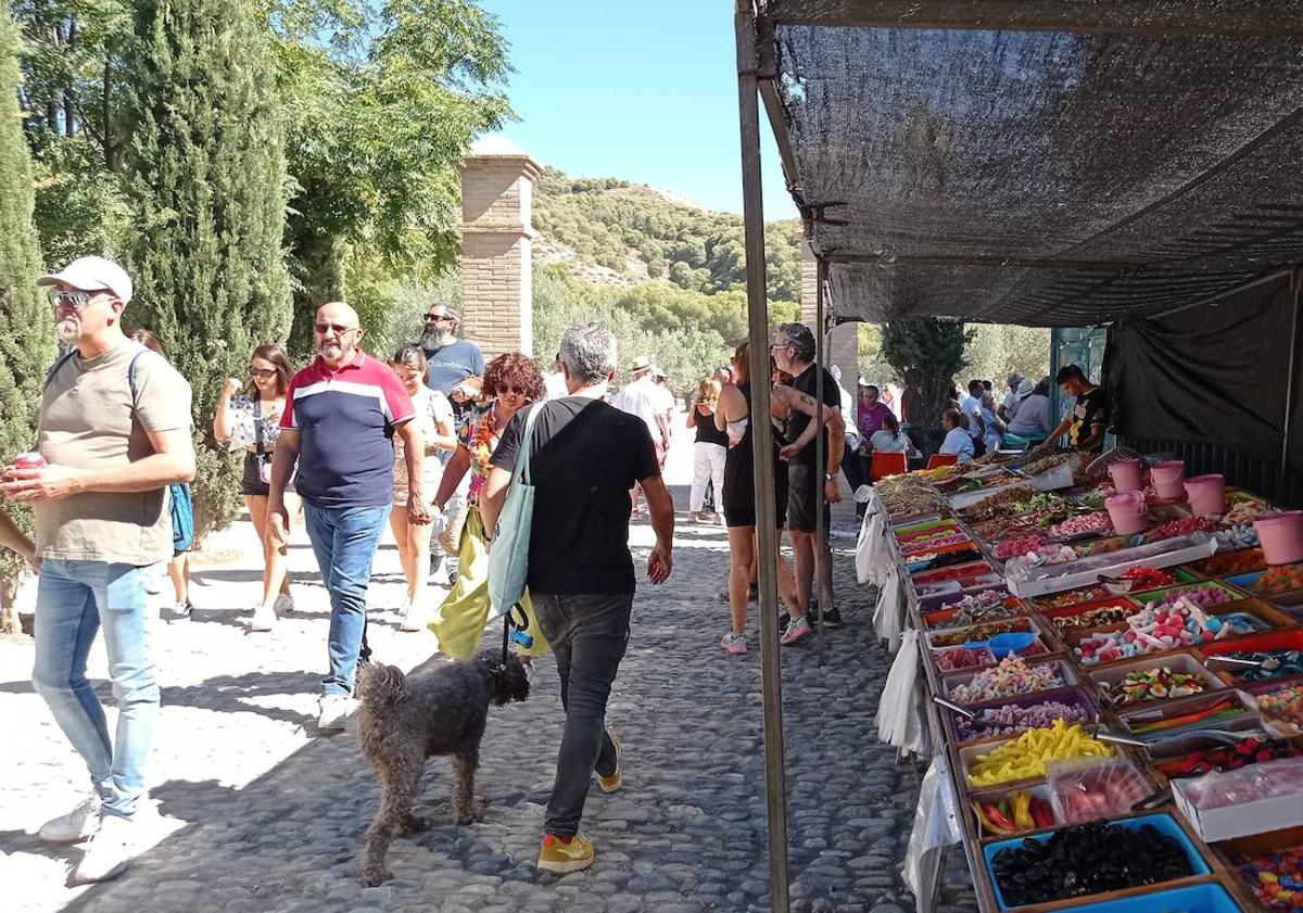 Imagen principal - Puestos con chucherías y bebidas fresca flanqueaban la ermita de San Miguel. Los selfies estaban omnipresentes en el mirador. Cola ante la ermita..