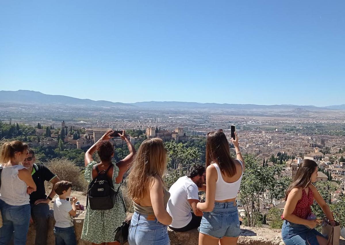 Imagen secundaria 1 - Puestos con chucherías y bebidas fresca flanqueaban la ermita de San Miguel. Los selfies estaban omnipresentes en el mirador. Cola ante la ermita..