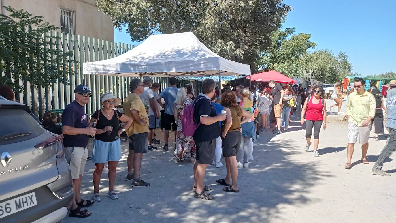 Imagen secundaria 1 - Una de las dos paelleras donde se preparó el arroz para mil personas a tres euros el plato. Mientras, la gente trasegaba cervezas o hacía cola para comprar los tiques.