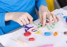 Imagen de archivo de un niño jugando con plastilina.