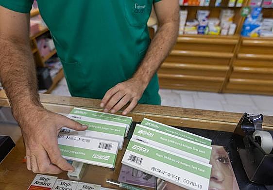 Farmacéutico muestra varios test covid.