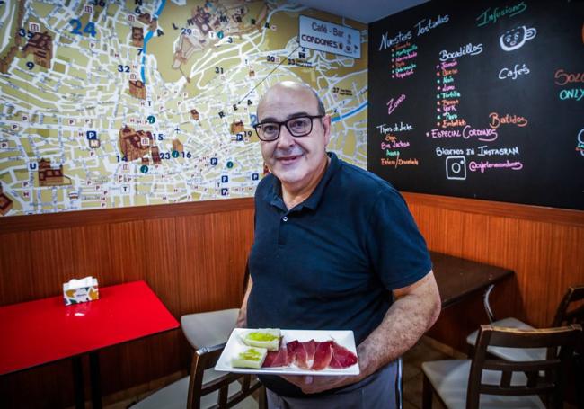 Paco Braserito, en su cafetería con un mapa gigante de Realejo a sus espaldas