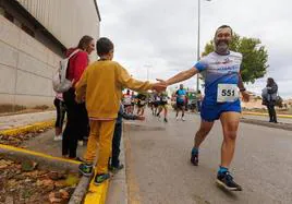 Un niño choca la mano a un corredor durante la carrera en Santa Fe.