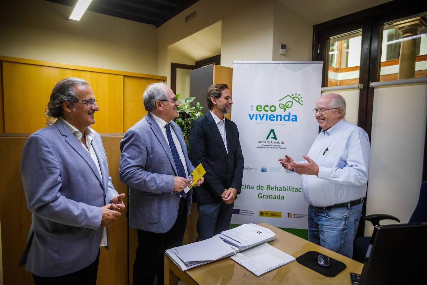 El vicedecano del colegio de Arquitectos Luis Alberto Martínez, el delegado de Fomento de la consejería, Antonio Ayllón y el decano del Colegio Ismael Rodríguez conversan con uno de los profesionales que atienden la nueva oficina.