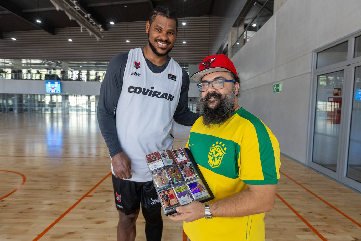 Roberto Castillo (d) posa con Cristiano Felicio y su colección 'trading cards' del brasileño.