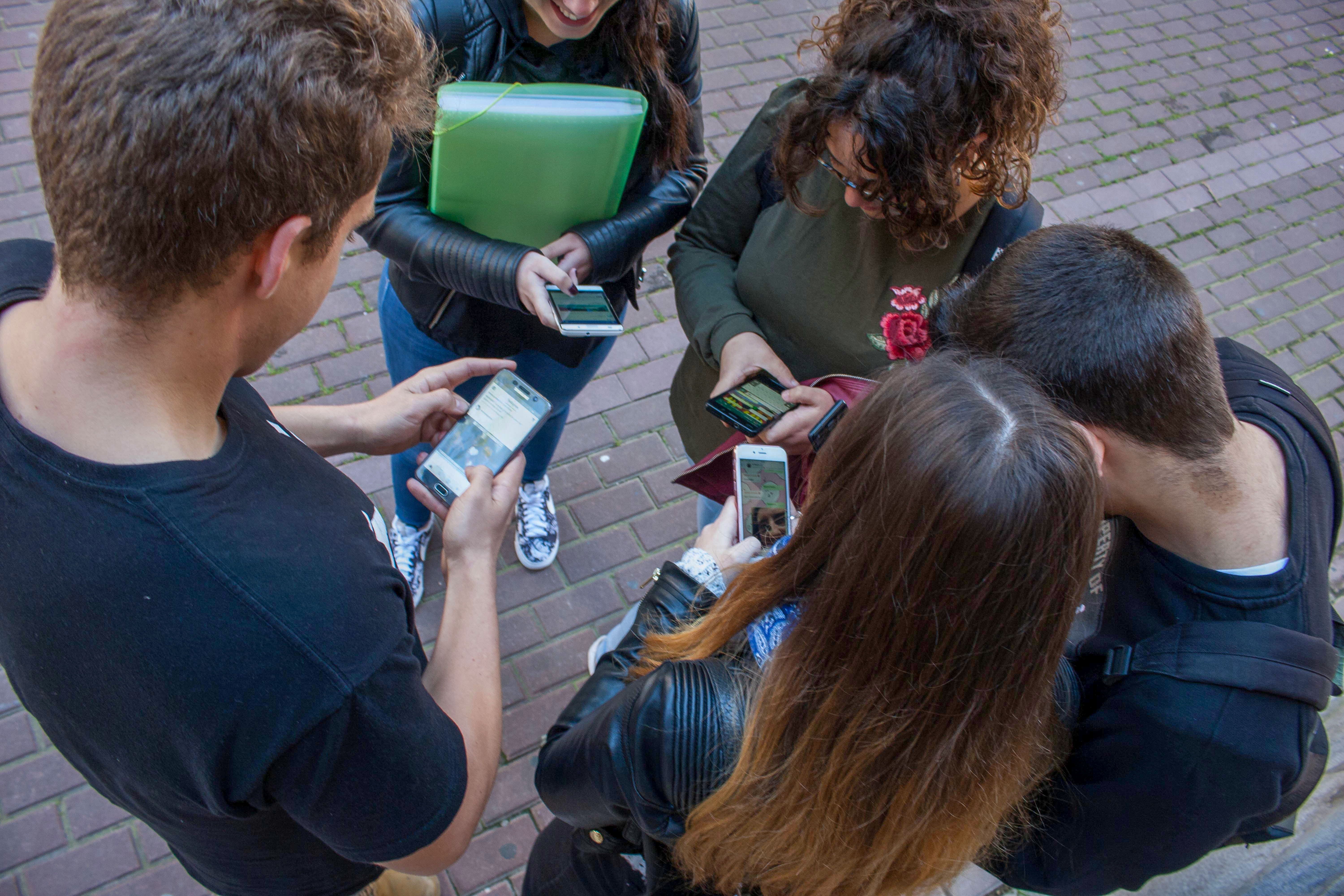 Un grupo de adolescentes consultan en los móviles sus cuentas en las redes sociales.