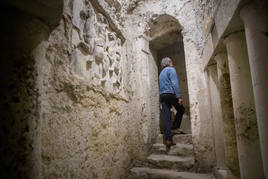 Pasillo de la galería donde se puede ver un medio relieve en una pared y unas columnas decorativas en otra.