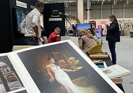 Una familia consulta presupuestos en el expositor de una empresa de fotografía.