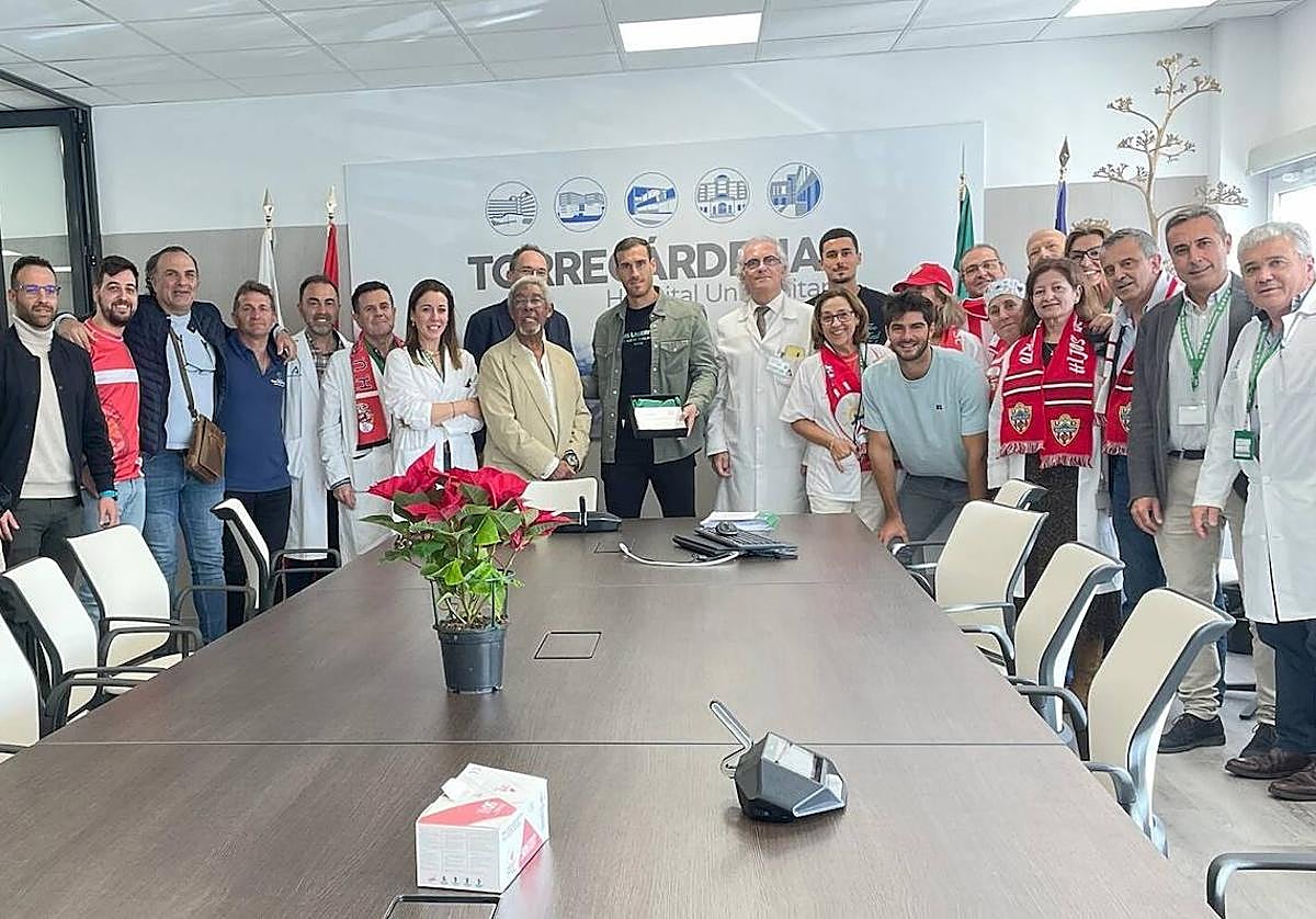 Facultativos miembros de la Peña Torrecárdenas de la UDA y los tres jugadores posan tras el encuentro en el centro hospitalario. 