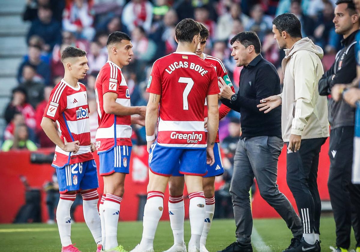 Los futbolistas del Granada escuchan al 'Cacique' Medina durante el partido contra el Athletic.