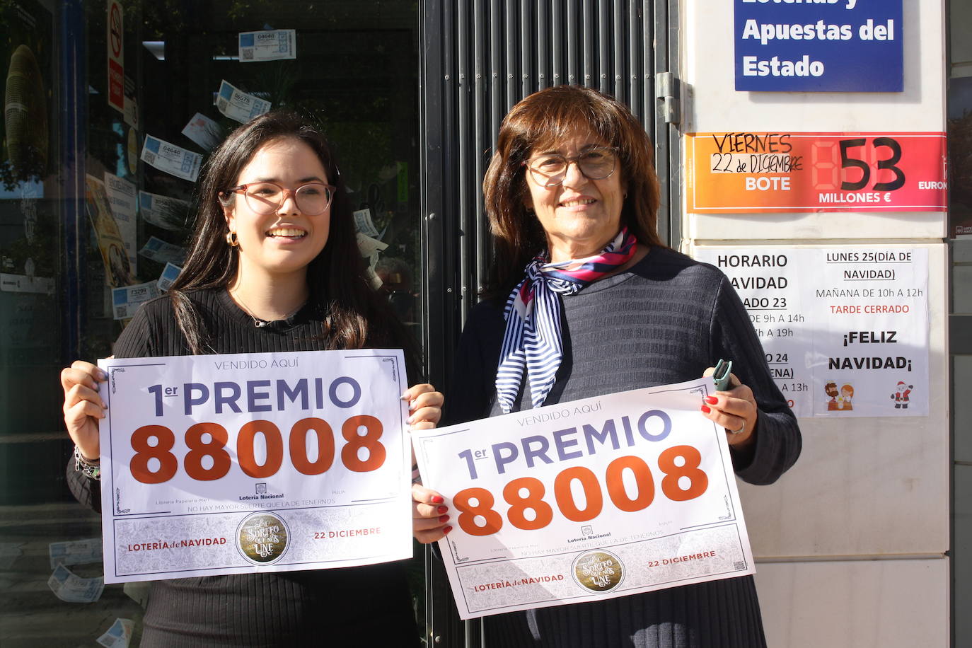 Las responsables de la Papelería Aurelia, con el número premiado en la mano.