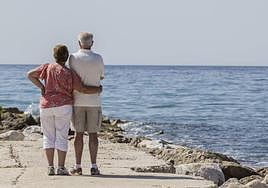 Una pareja, paseando junto al mar.