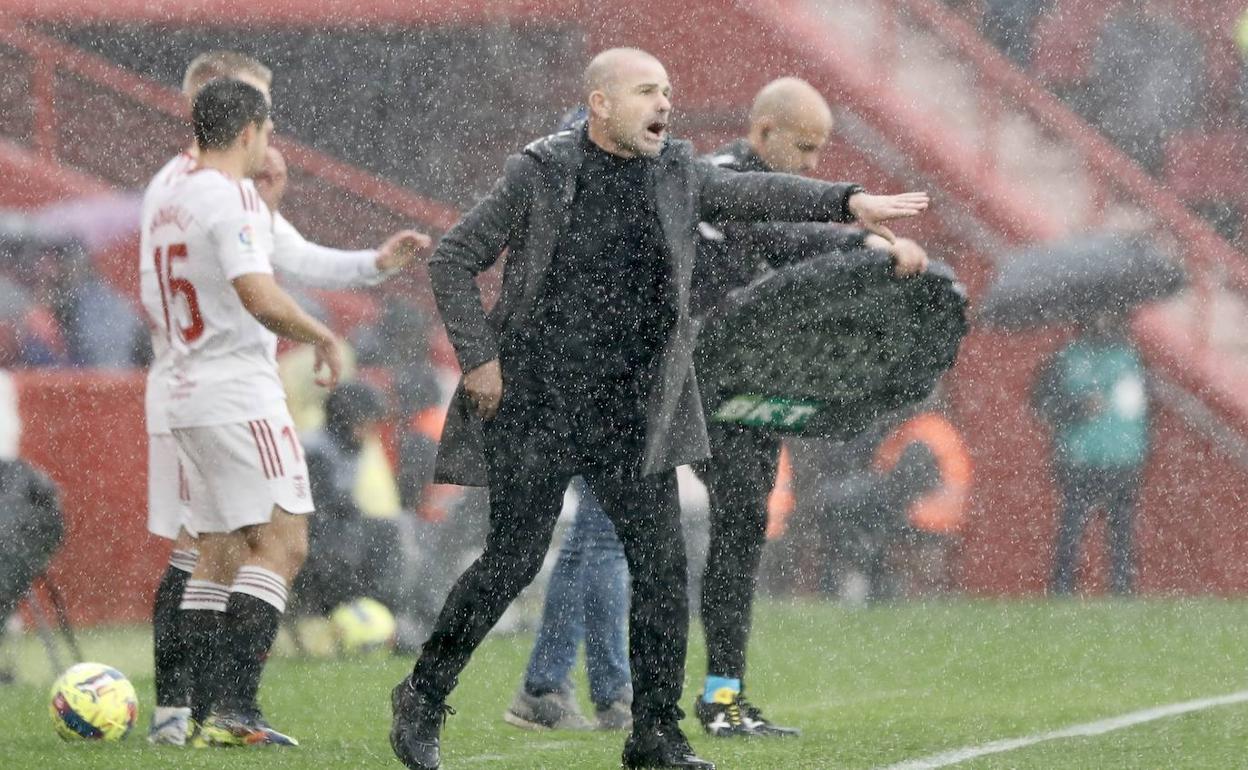 Paco López da indicaciones a sus futbolistas bajo la lluvia. 