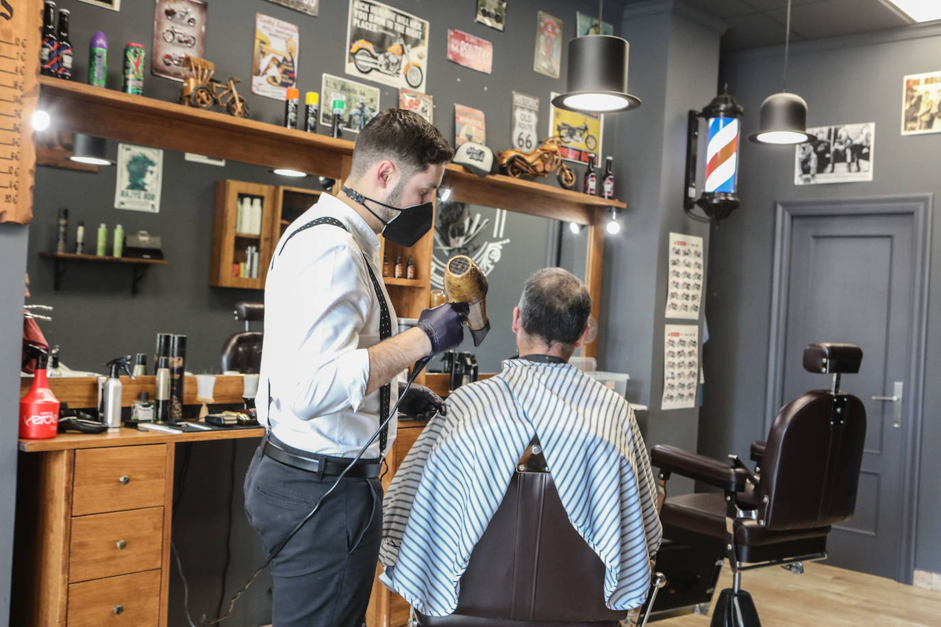 Un peluqero reliza un corte de pelo. 