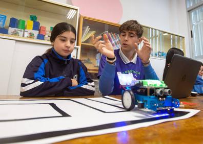 Imagen secundaria 1 - Arriba, monitores de ESO enseñan a los pequeños de Infantil a dar órdenes a un robot basándose en el pensamiento computacional. Abajo, Saul Velázquez explica el funcionamiento de su bot a una compañera y dos alumnas abren las puertas al aula de robótica. 