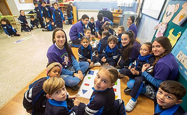 Imagen principal - Arriba, monitores de ESO enseñan a los pequeños de Infantil a dar órdenes a un robot basándose en el pensamiento computacional. Abajo, Saul Velázquez explica el funcionamiento de su bot a una compañera y dos alumnas abren las puertas al aula de robótica. 