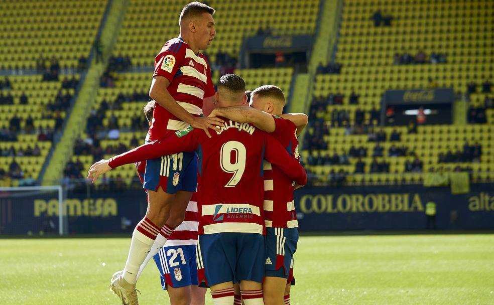 Los compañeros abrazan a Shon Weissman tras su primer gol con el Granada en el Estadio de la Cerámica./ LOF