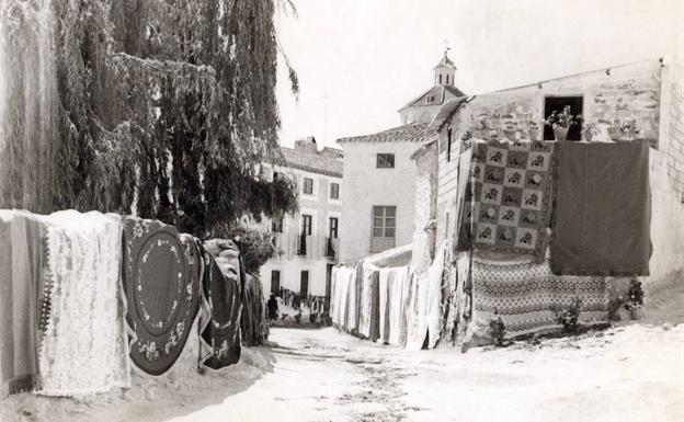 Calle engalanada con macetas, mantas y mantones para el día del Corpus. 