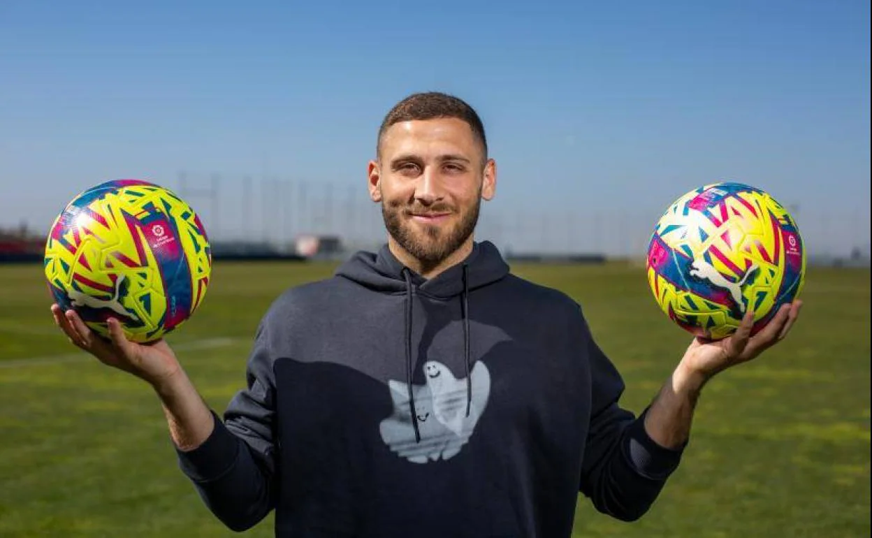 Shon Weissman posa divertido con un balón sobre cada mano. 