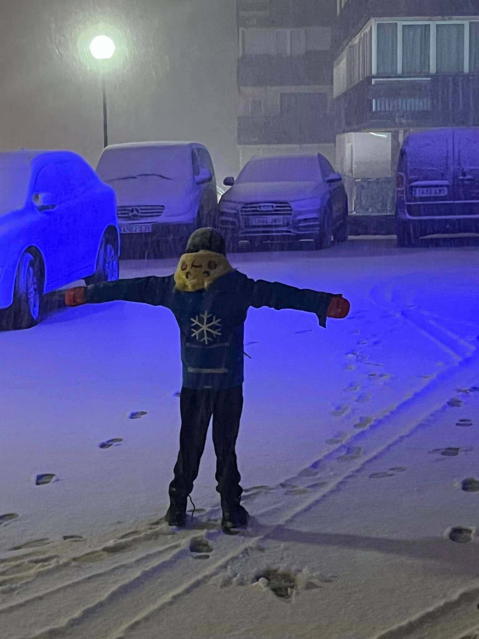 Un niño juega bajo la última nevada en la estación de Sierra Nevada.