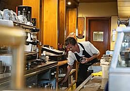 Un camarero atendiendo clientes en un bar.