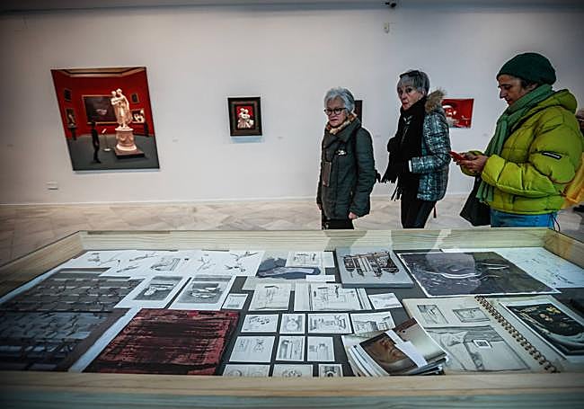 Un grupo de visitantes, ante una vitrina con bocetos.