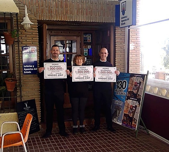 Los gerentes de la administración de Cádiar con los carteles del premio del millón de euros
