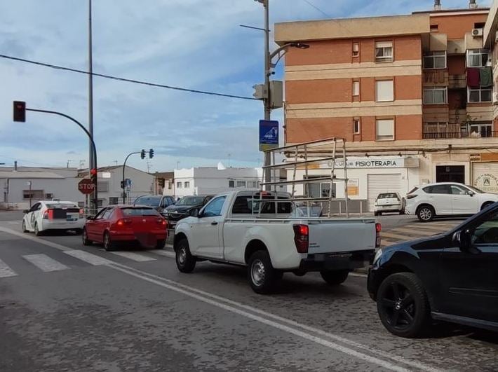 Varios vehículos se acumulan a la salida del pueblo ante el polémico semáforo de Pinos Puente.