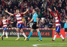 Martínez Munuera, rodeado por futbolistas del Granada que le protestan.