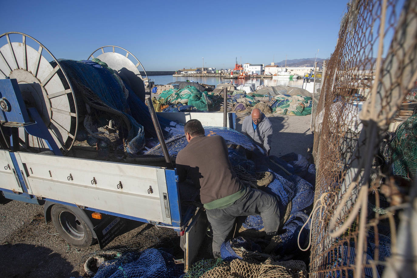 Pescadores arreglan sus redes en el puerto de Motril.