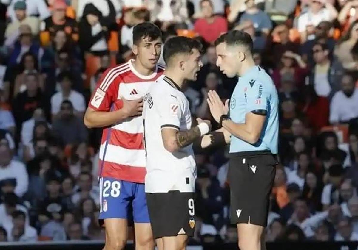 García Verdura dialoga con Hugo Duro tras señalar el penalti de Raúl Torrente, aún alucinado.