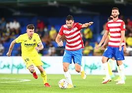 Antonio Puertas conduce un balón ante Alberto Moreno en la última visita del Granada al Estadio de la Cerámica para enfrentarse al primer equipo del Villarreal, en 2021.