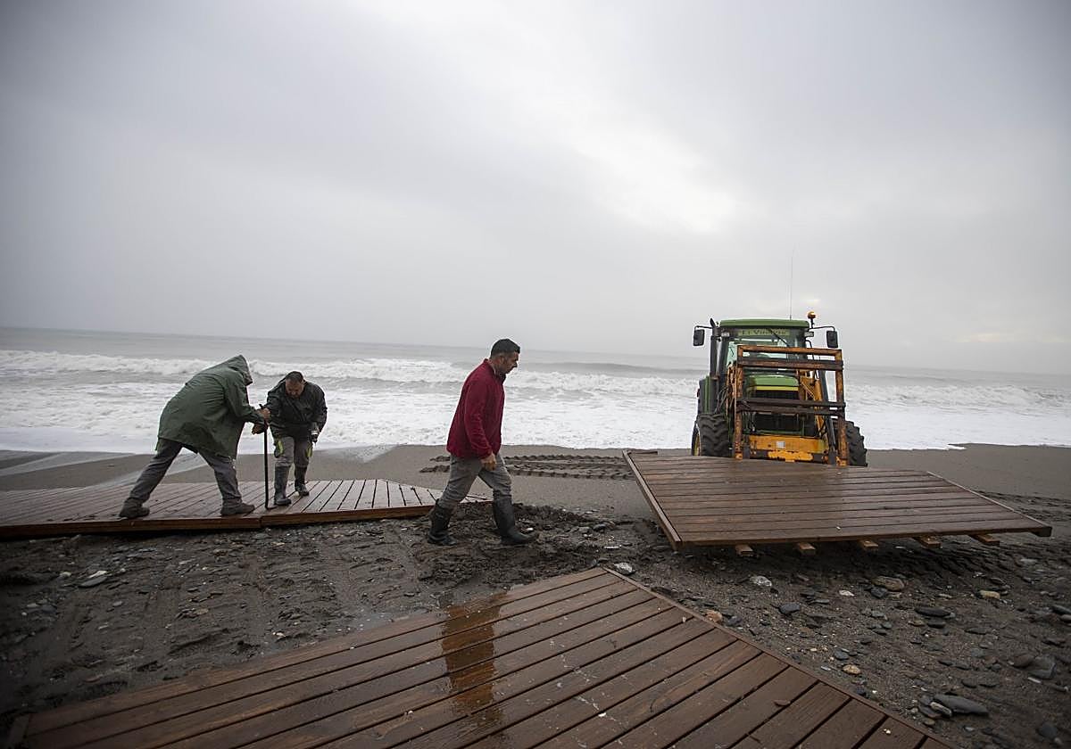 Operarios arreglan los destrozos causados por el temporal en Playa Granada.