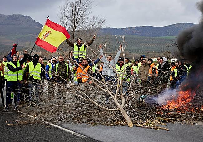 Los agricultores, congregados ante una de las hogueras colocadas en medio de la A-92.