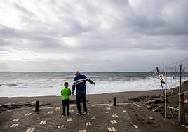 Dos vecinos observan los destrozos de la playa.