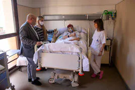 Mercedes, paciente ingresada por ELA, junto a su hija y los sanitarios que le atiende en el hospital de San Rafael en Granada.
