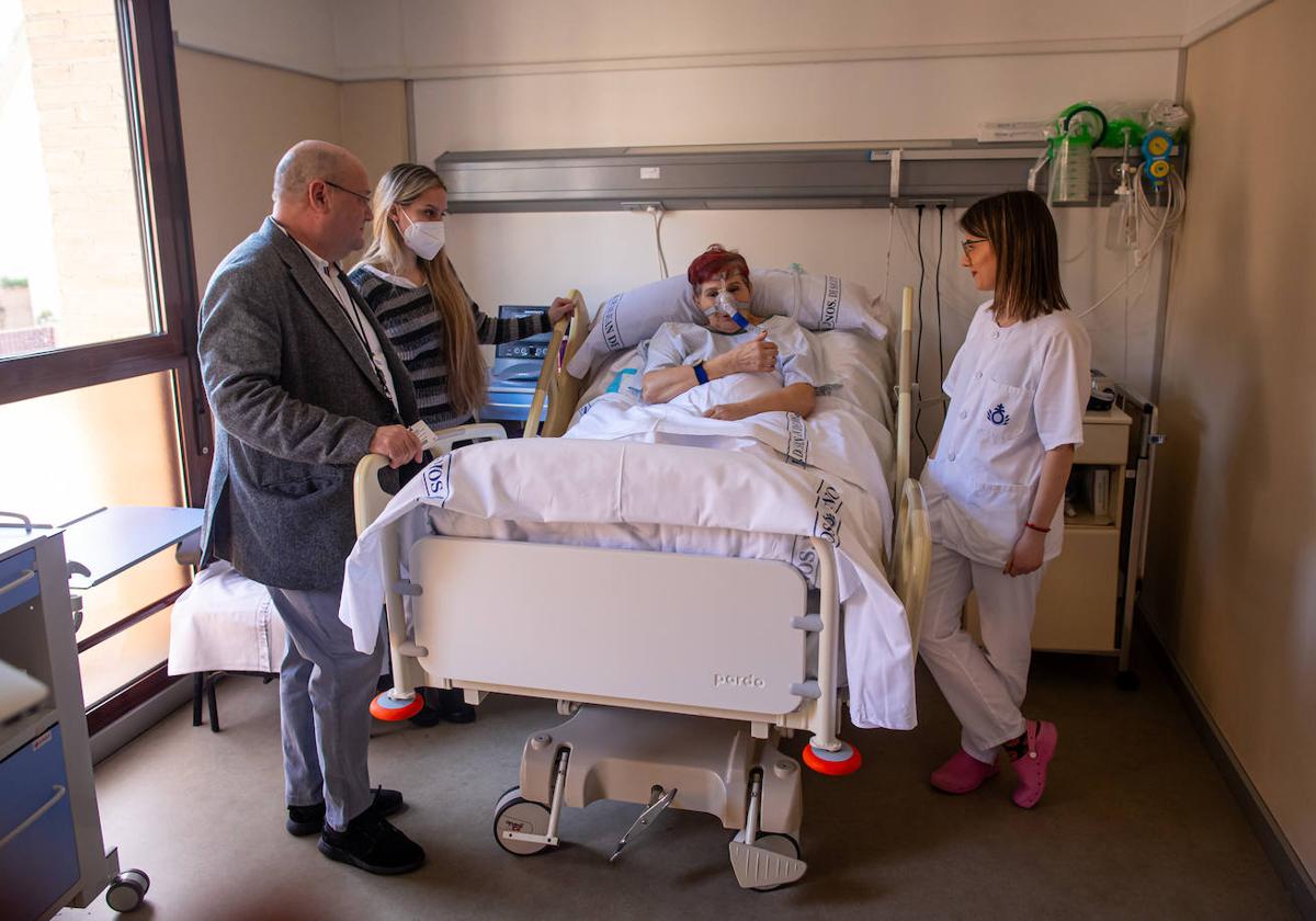 Mercedes, paciente ingresada por ELA, junto a su hija y los sanitarios que le atiende en el hospital de San Rafael en Granada.