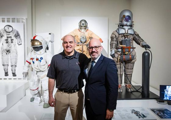 Carlos García-Galán, VI Premio Viajero del Tiempo, junto a Amador Carmona, director comercial de CaixaBank para Granada y Jaén, posan junto a trajes de astronauta expuestos en el Parque de las Ciencias.