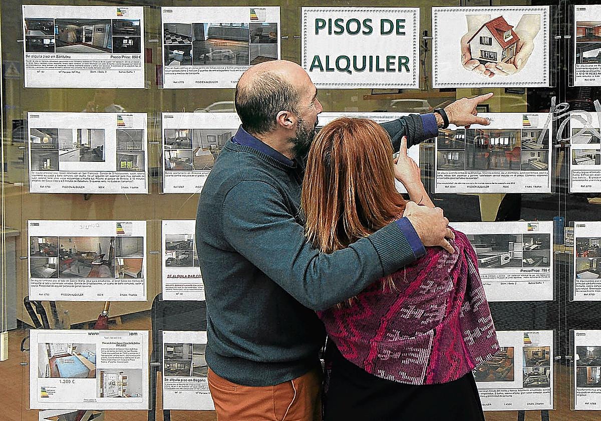 Una pareja observa ofertas de alquiler en una inmobiliaria en una imagen de archivo.