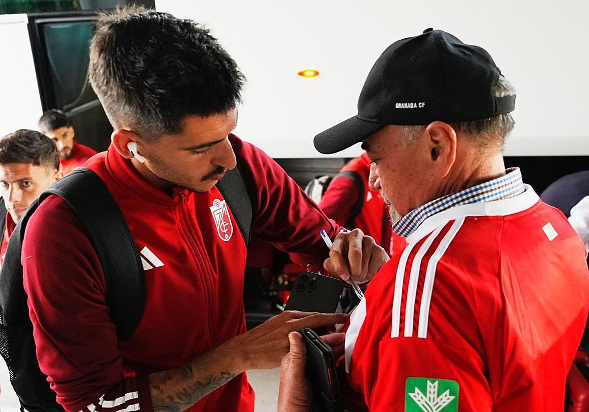 Carlos Neva firma la camiseta a un aficionado a la llegada del Granada a Palma de Mallorca.